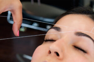 experiancing perfect eyebrow threading in dallas. women left eyebrow threading in progress at brow bar threading salon